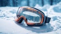 Ski or snowboard goggles lie on the snow against the backdrop of the beautiful Alpine mountains with space for text.