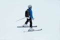 Ski sports in winter. Skier in blue ski suit rises on lift up mountain slope. Vacation in mountains in ski resort.