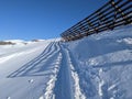 Ski tour below an avalanche barrier in glarus switzerland. track in the snow. skimo