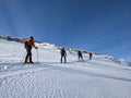 Ski touring group on the way to the summit. Mountaineering with skis in winter on the Gemsfairenstock in Uri. Swiss Alps