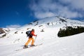 Ski touring man reaching the top in spectacularly snowy mountains at sunny day Royalty Free Stock Photo