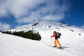 Ski touring man reaching the top in spectacularly snowy mountains at sunny day Royalty Free Stock Photo