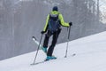 Ski touring, a person is performing a 45 degree turn while walking uphill with skis, modern equipment for ski touring, snow is Royalty Free Stock Photo