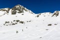 Ski touring or winter skiing tourism. A group of skiers approaching a snowy slope in search of firn for the descent