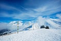 Ski track start on top of a mountain over summits in clouds Royalty Free Stock Photo