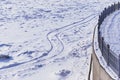 Ski tracks and animal tracks. A fragment of the snow-covered city embankment of the Amur River. Winter morning. Metal