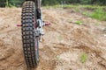 Skid-resistant tread on motorcycle tire, motocross bike in sandy track, rear view