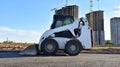 Skid-steer loader for loading and unloading works on city streets. ÃÂ¡ompact construction equipment for work in limited conditions Royalty Free Stock Photo