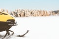 Skidoo snowmobile on snow in middle of frozen lake with beautiful winter landscape in background