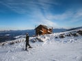 The skier is on the background of a wooden house in the snow-capped mountains. A hotel for people who love winter holidays. Ski Royalty Free Stock Photo