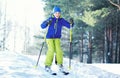 Skier child wearing a sportswear is skiing in winter forest Royalty Free Stock Photo