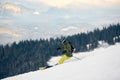 Skier descending from snow-covered high mountain peak. Extreme back-country skiing concept. Mountains view on background Royalty Free Stock Photo