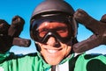 Skier dressed in ski helmet and ski goggles showing the two `victory` gestures portrait