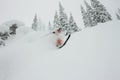 Skier freerider jumping from a snow ramp in the sun on a background of forest and mountains Royalty Free Stock Photo