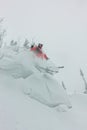 Skier freerider jumping from a snow ramp in the sun on a background of forest and mountains Royalty Free Stock Photo