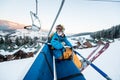 Skier guy sitting at ski chair lift in beautiful day and turns back. Close-up. Concept of skiing. Royalty Free Stock Photo