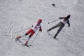 A skier in a light green jacket runs a distance in the forest .