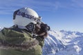 Skier man with orange ski glasses in white helmet make photoshoot on top in Alps mountains. On the background of Royalty Free Stock Photo