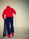 Skier in red winter jacket with fun snowshoes stay in snow in mountains.