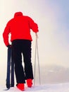 Skier in red winter jacket with small fun skis stay in snow.