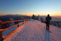 A skier is resting at a ski resort with beautiful view to the snowy mountains.