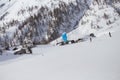 Skier riding a snowkite near to the mountain cabins on Simplon Pass, Switzerland