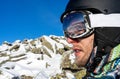Skier's snowboarder equipment: helmet mask, glasses. Reflection in ski goggles, snowy stones. Man on ski resort