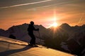 skier silhouette against sunset with snowcapped mountains in the background