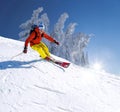 Skier skiing downhill in high mountains against blue sky Royalty Free Stock Photo