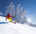 Skier skiing downhill in high mountains against blue sky Royalty Free Stock Photo