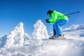 Skier skiing downhill in high mountains against against the fairytale winter forest Royalty Free Stock Photo