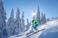 Skier skiing downhill in high mountains against the fairytale winter forest Royalty Free Stock Photo