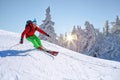 Skier skiing downhill in high mountains against against the fairytale winter forest with sunset Royalty Free Stock Photo