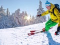 Skier skiing downhill in high mountains against against the fairytale winter forest with sunset Royalty Free Stock Photo