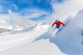 Skier skiing downhill in high mountains.