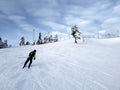 A skier slides down a mountain slope against the background of a sky covered with clouds