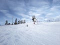 A skier slides down a mountain slope against the background of a sky covered with clouds.