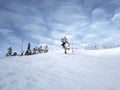 A skier slides down a mountain slope against the background of a sky covered with clouds