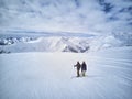 Skier and snowboarder standing on mountain top against blue sky and mountains panorama. Two active friends have vacation Royalty Free Stock Photo