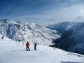 Skier standing on a slope. Girl in a light suit, the helmet and mask in skiing is to ski. In the background snow-capped mountains Royalty Free Stock Photo