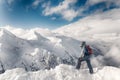 Skier stay with skis on big rock on mountains backdrop. Bansko, Bulgaria