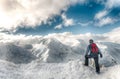 Skier stay with skis on big rock on mountains backdrop. Bansko, Bulgaria