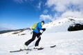 Skier tourist with backpack on background of bright blue sky and beautiful mountain panorama. Royalty Free Stock Photo