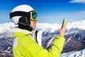 Skier woman with cell phone over mountains