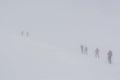 Skiers ascending a slope in heawy fog Royalty Free Stock Photo