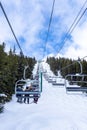 Skiers on Chairlift Up a Ski Slope in the Canadian Rockies Royalty Free Stock Photo