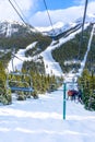 Skiers on Chairlift Up a Ski Slope in the Canadian Rockies Royalty Free Stock Photo