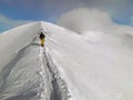 Skiers climb the trail on snow-capped top