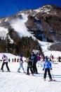 Skiers look up at the high slopes