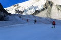 Skiers pulled by ski lift towards mountain Allalinhorn ski slope and snow mountain panorama during summer in Saas-Fee, Pennine